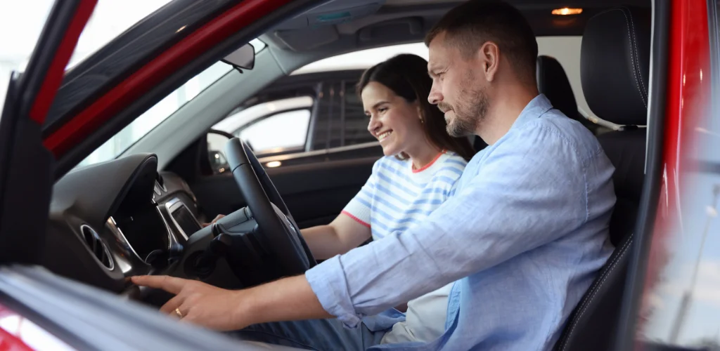Couple sitting in a car reviewing car insurance options in Australia 2025