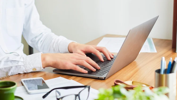 Person comparing car insurance quotes online using laptop